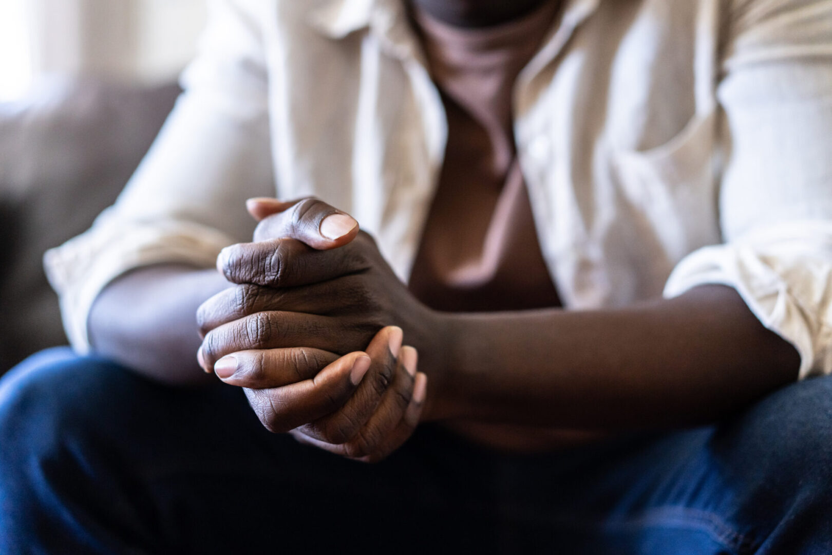 Person sitting with folded hands