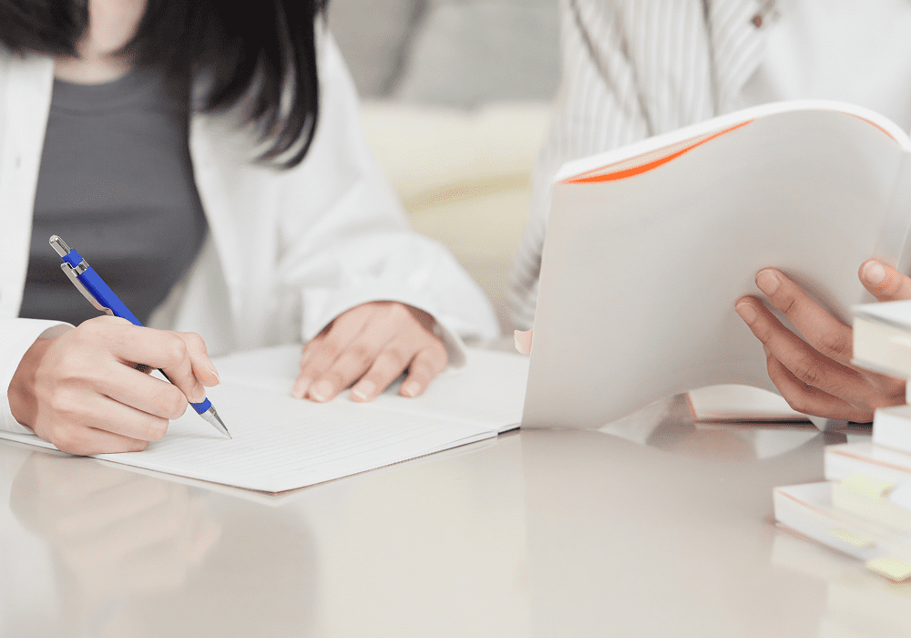 Hands writing and holding documents
