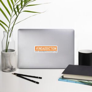 Laptop with #ENDADDICTION sticker on desk