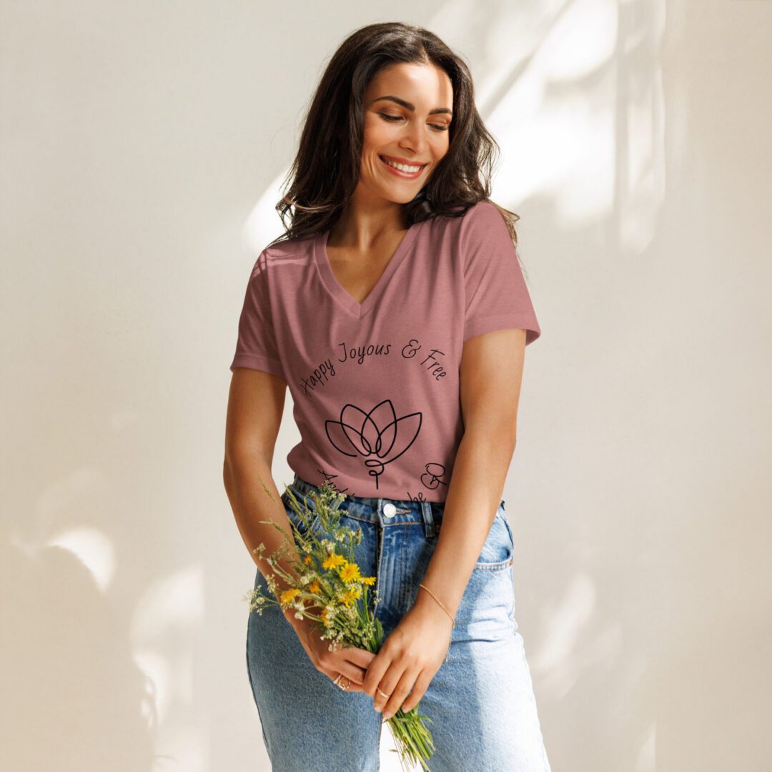 Woman in pink tee holding yellow wildflowers